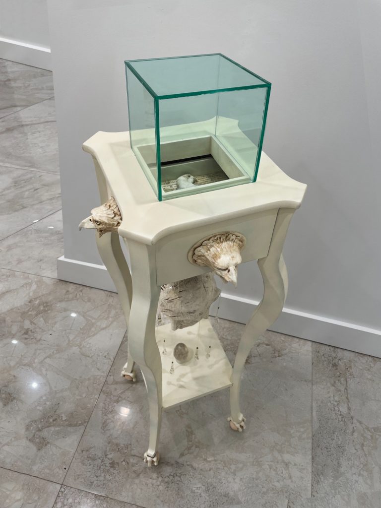 "Nostalgia", 2023. 47” H x 13” L x 13” Deep, Ceramic, wood, glass, quartz & taxidermied bird.